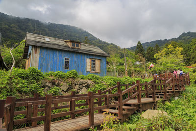 Built structure against trees and mountains against sky