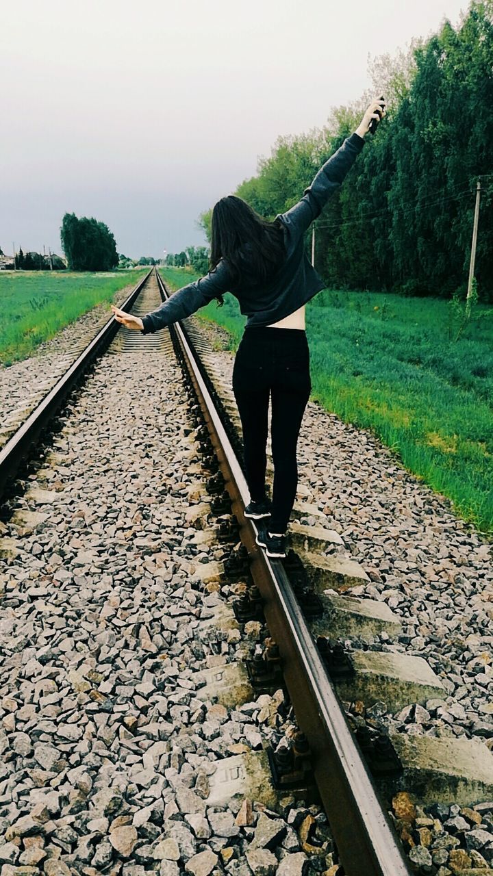 FULL LENGTH OF MAN STANDING ON RAILROAD TRACKS