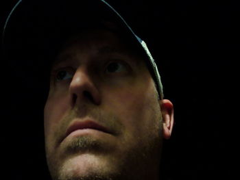 Close-up portrait of man against black background