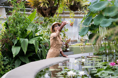 Woman standing by flowering plants