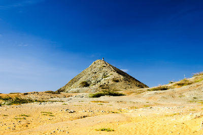 Scenic view of landscape and mountain against blue sky