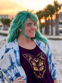 Girl with teal hair poses on the beach