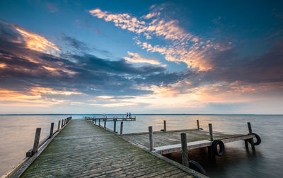 Pier over sea against sky during sunset