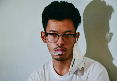 Portrait of young man against wall