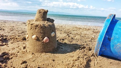 Sandcastle at beach against sky