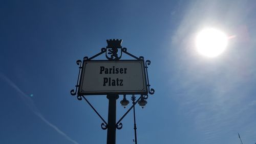 Low angle view of information sign against blue sky