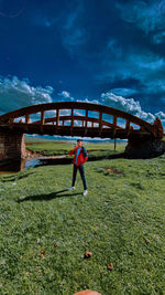 Man on bridge against sky