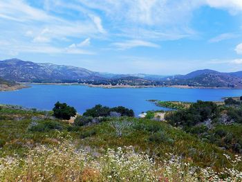 Scenic view of lake by mountains against sky