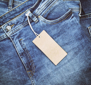 Close-up of labels hanging from jeans