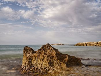 Scenic view of rocks on beach against sky