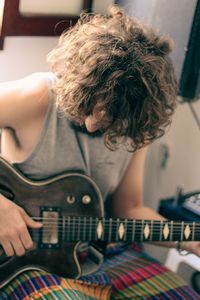 Midsection of man playing guitar