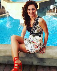 Portrait of happy woman sitting in swimming pool