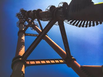 Low angle view of rollercoaster against clear sky at dusk