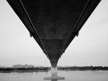 Low angle view of bridge over river against sky