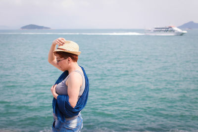 Side view of man standing against sea