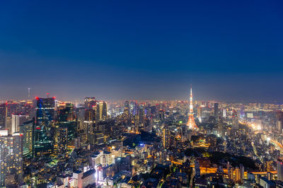 Illuminated cityscape against sky at night