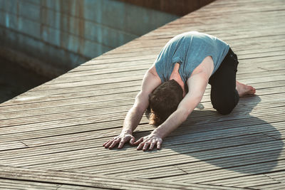 Full length of man relaxing on wood