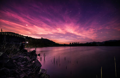 Scenic view of lake against sky at night