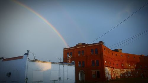 Rainbow over building against sky