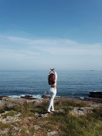 Full length of woman standing by sea against sky