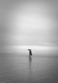 Silhouette man in sea against sky