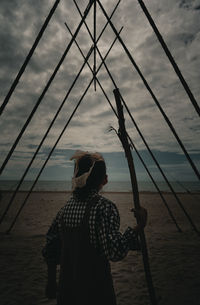 Rear view of girl looking at sea shore against sky