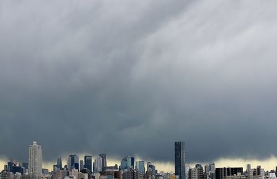 Low angle view of city against cloudy sky