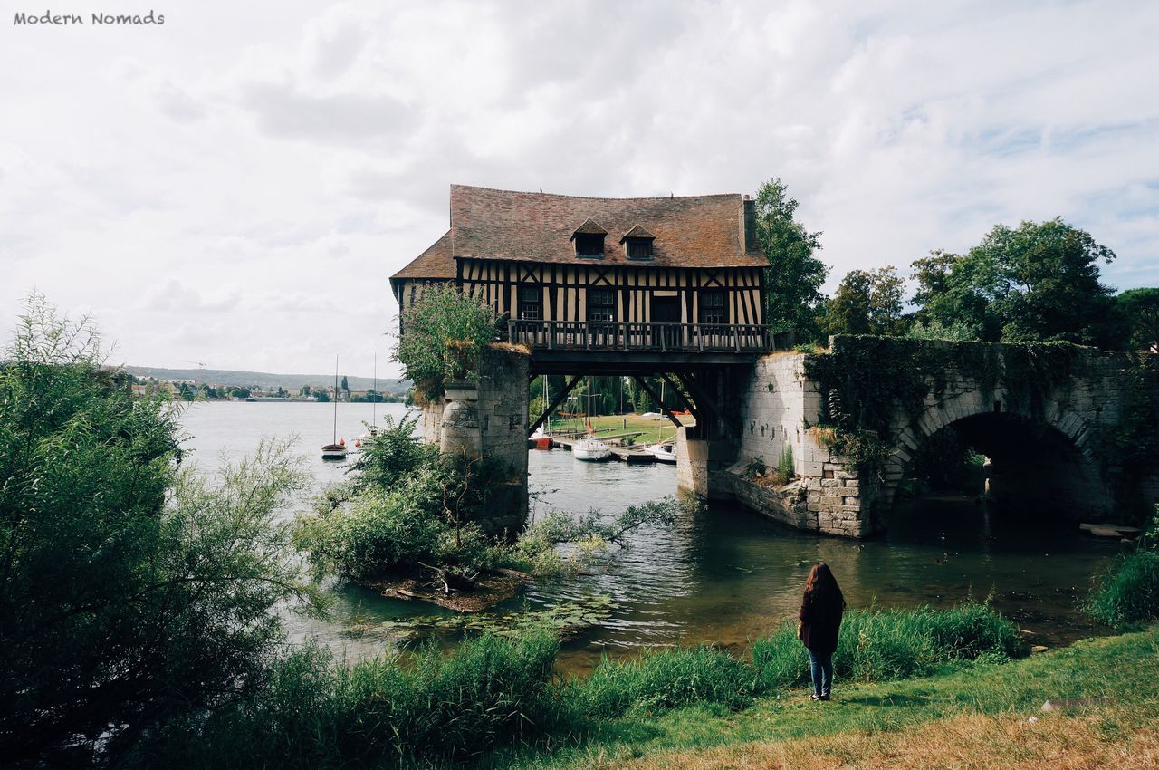 architecture, built structure, building exterior, water, cloud - sky, full length, sky, bridge - man made structure, river, pets, plant, outdoors, day, green color, domestic animals, garden, cloudy, riverbank