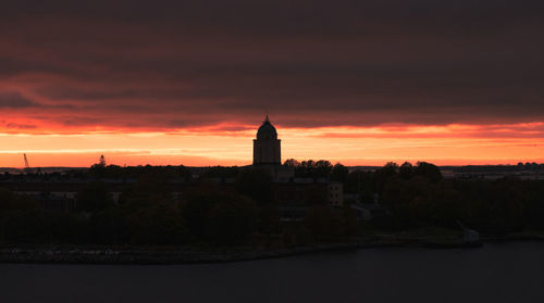 Buildings against cloudy sky at sunset