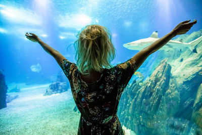 Rear view of woman standing in sea