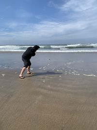 Full length of woman on beach against sky