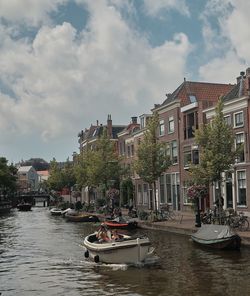 Boats moored in river against buildings in city