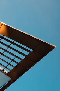 Minimalist photo of the corner of a building against a clear blue sky. 