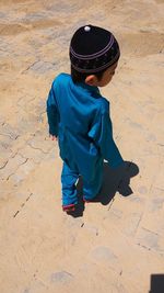 Full length of boy in traditional clothing walking on footpath during sunny day