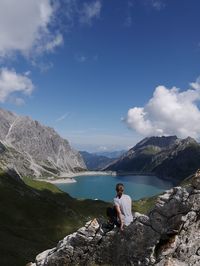 Rear view of woman looking at mountains and lake