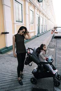 Full length of woman sitting on wall