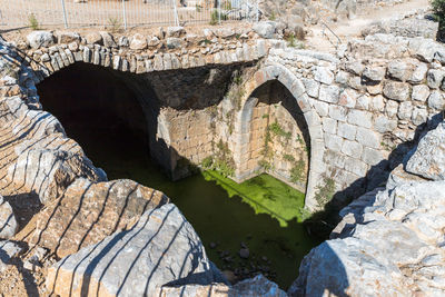 Arch bridge over rocks against river