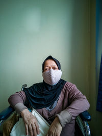 Portrait of a senior woman wearing hijab on wheelchair in a hospital.