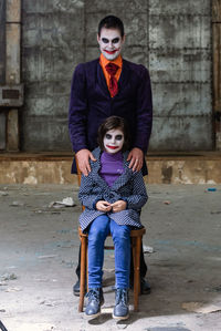 Portrait of a smiling young man standing against wall