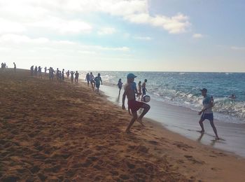 People at beach against sky
