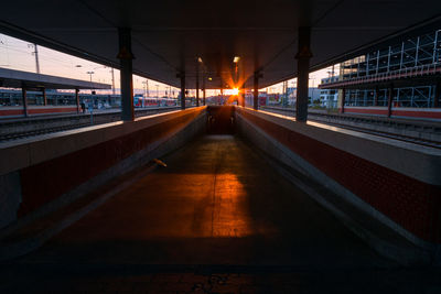 Empty railroad station platform against sky during sunset