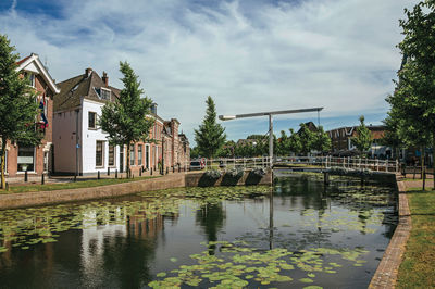 Canal with brick houses and bascule bridge in weesp. a pleasant small village in netherlands.