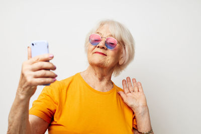 Young woman using mobile phone against white background