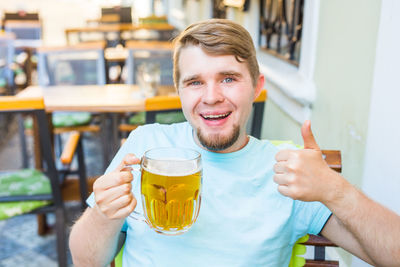 Portrait of a smiling young man drinking glass