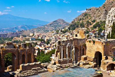 Panoramic view of old buildings and mountains against blue sky