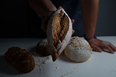 Close-up of hand holding bread on table