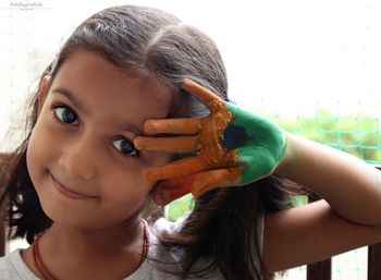 Close up of a girl with little smile saluting with colored hand