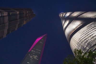 Low angle view of illuminated buildings against blue sky