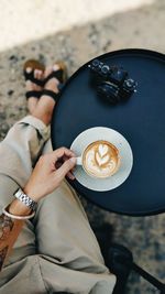 Low section of woman holding coffee cup