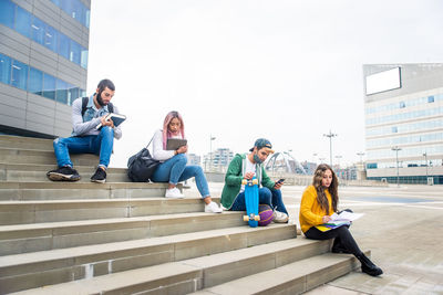 Students studying while sitting on staircase